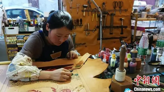 The workshop's keeper working leather at her bench