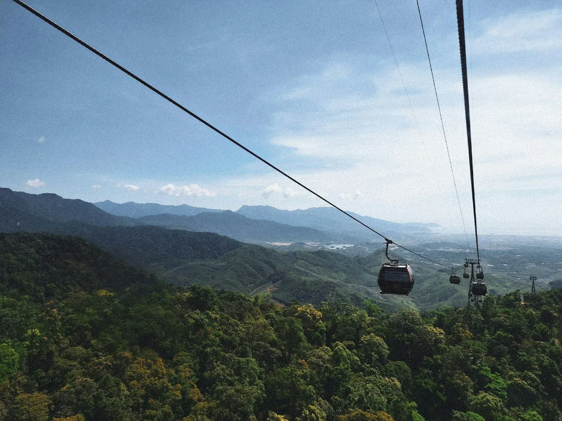 A cable car crossing the forested mountain