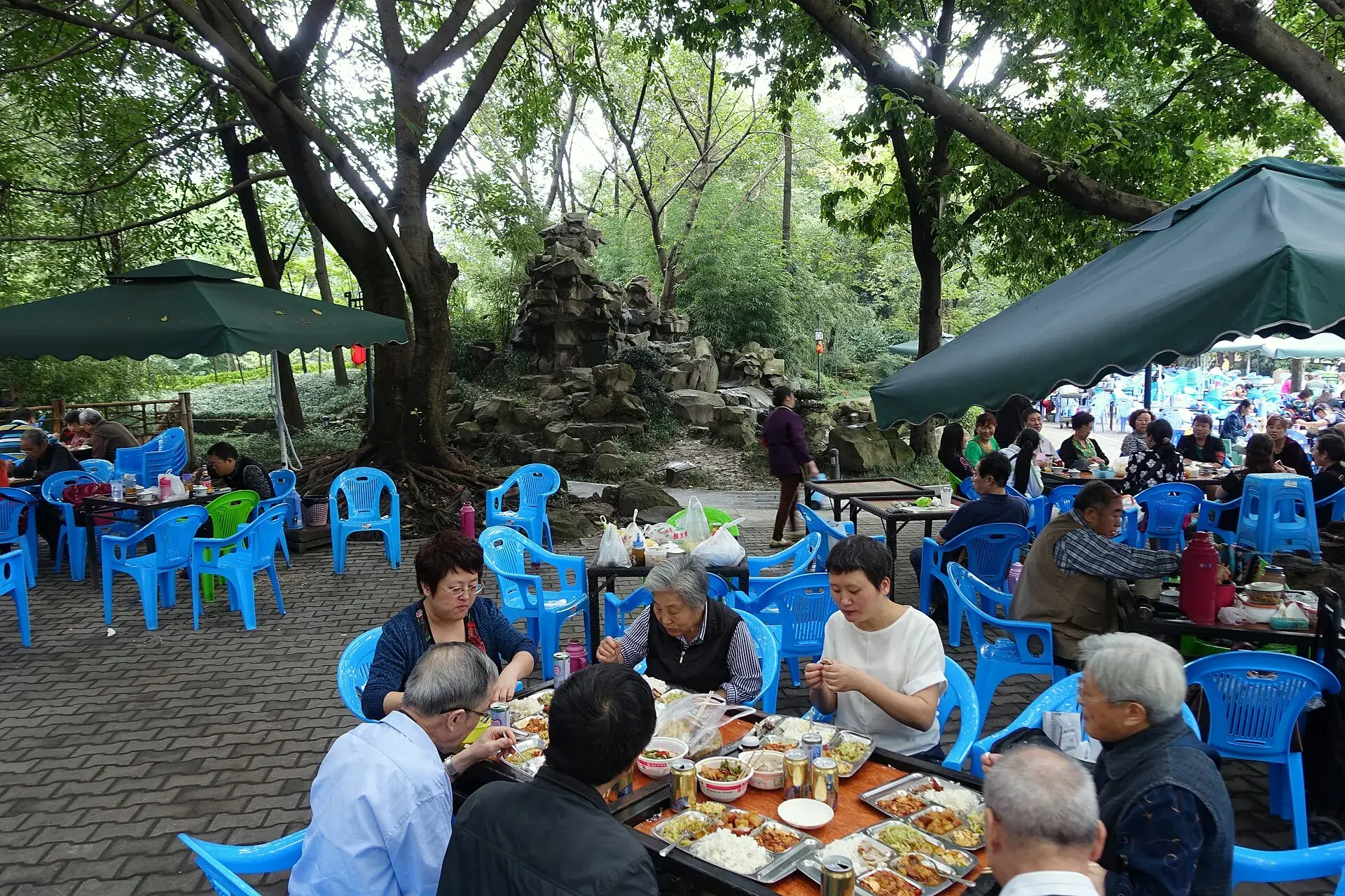 A table of Sichuan dishes shared outdoors in a Chengdu park