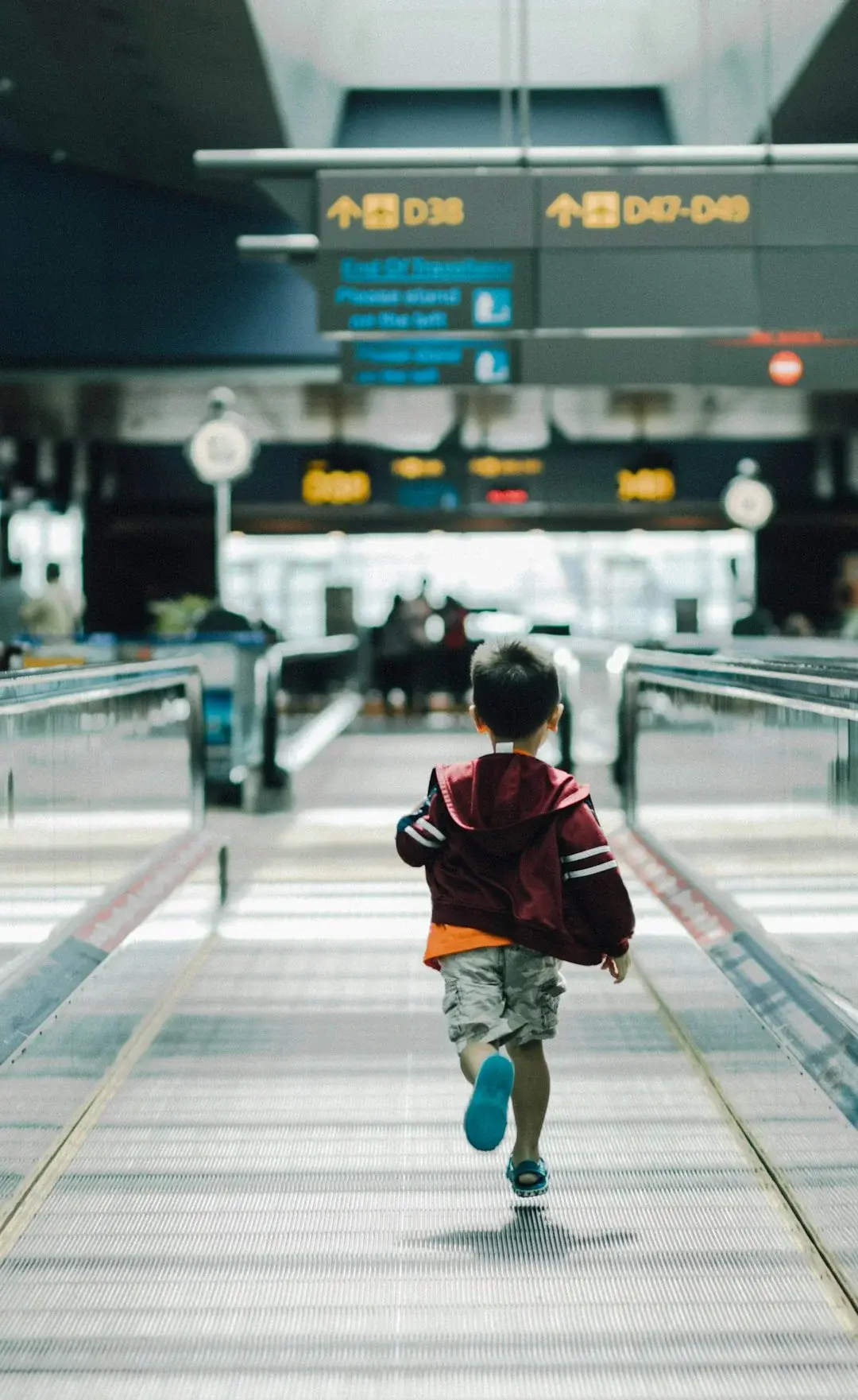 A family with a young child walking through a modern Chinese airport terminal