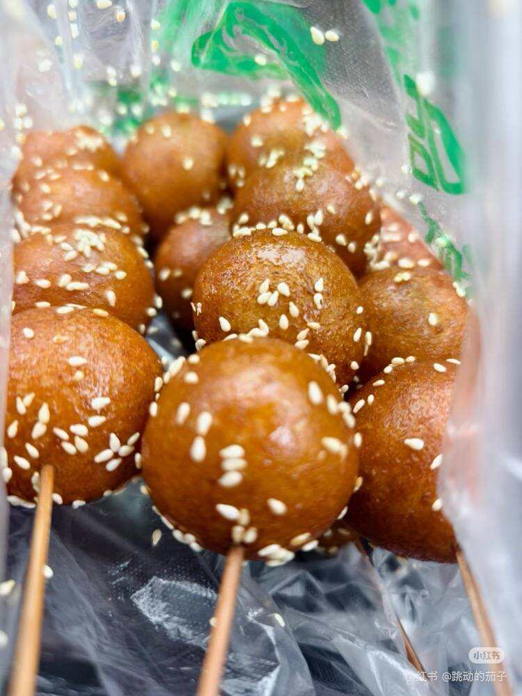 Tang you guo zi — skewered fried dough balls dusted with sesame