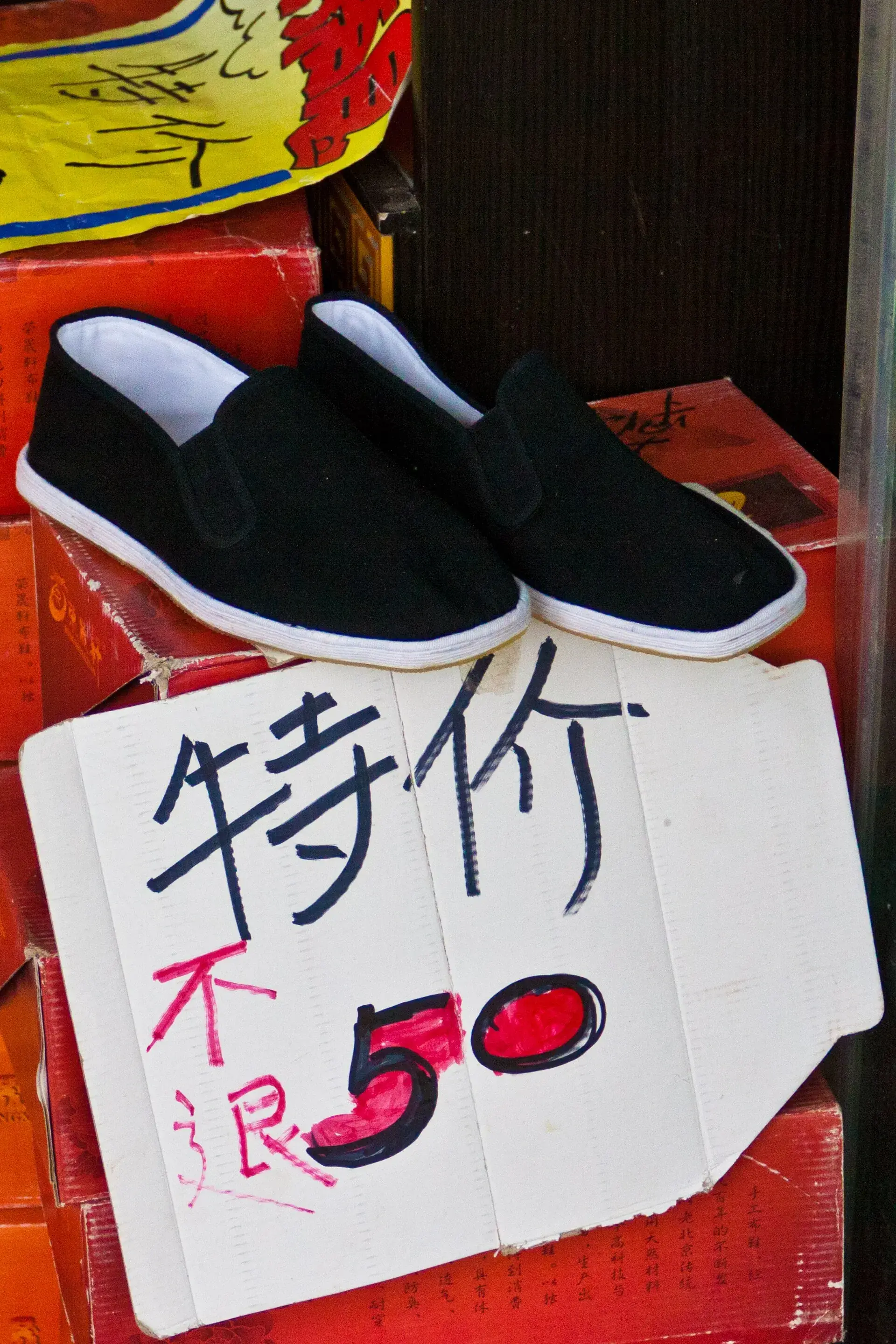 Plain black cloth shoes with white layered soles on a market stall