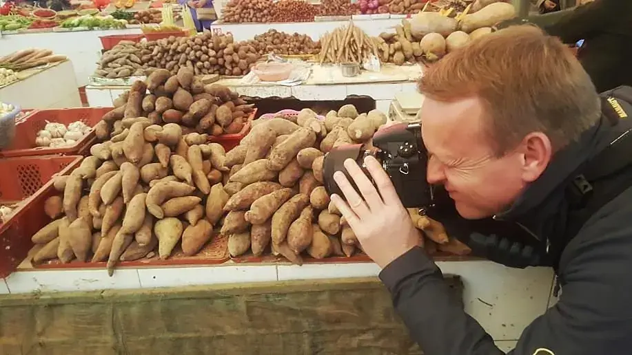 A guest photographing a produce stall in the market