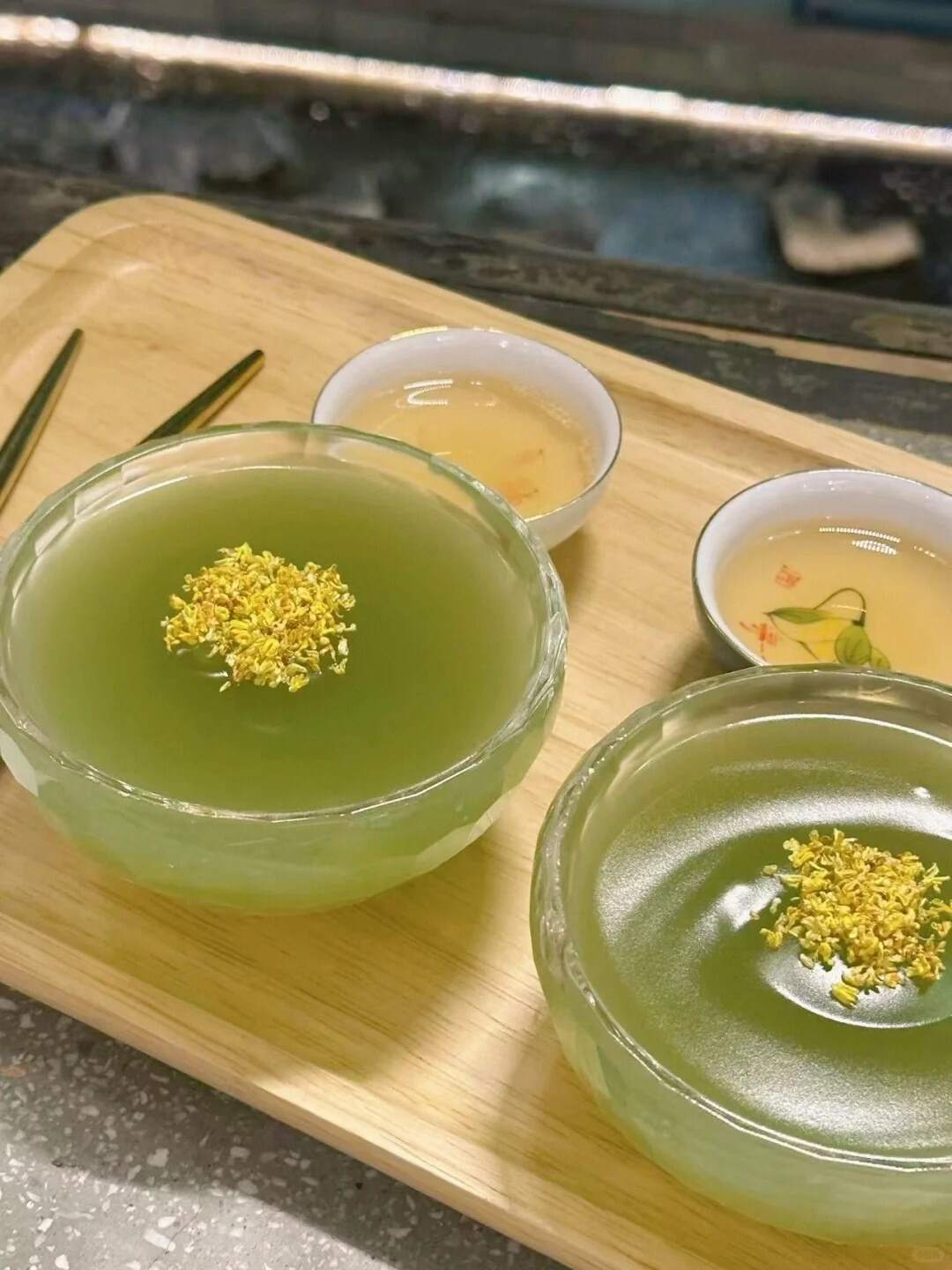 Lotus root powder topped with osmanthus on a wooden tray