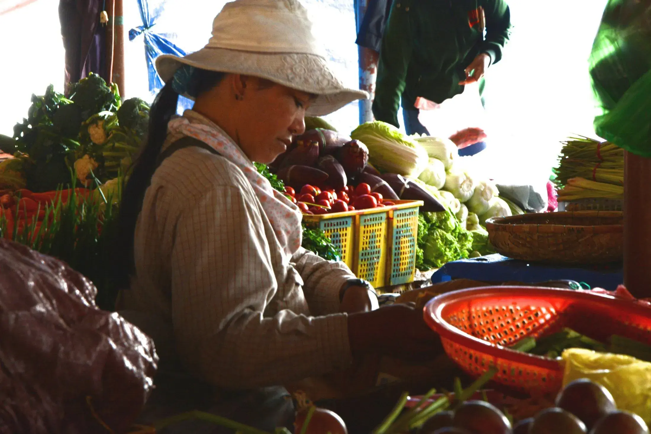 A busy wet market aisle stacked with produce
