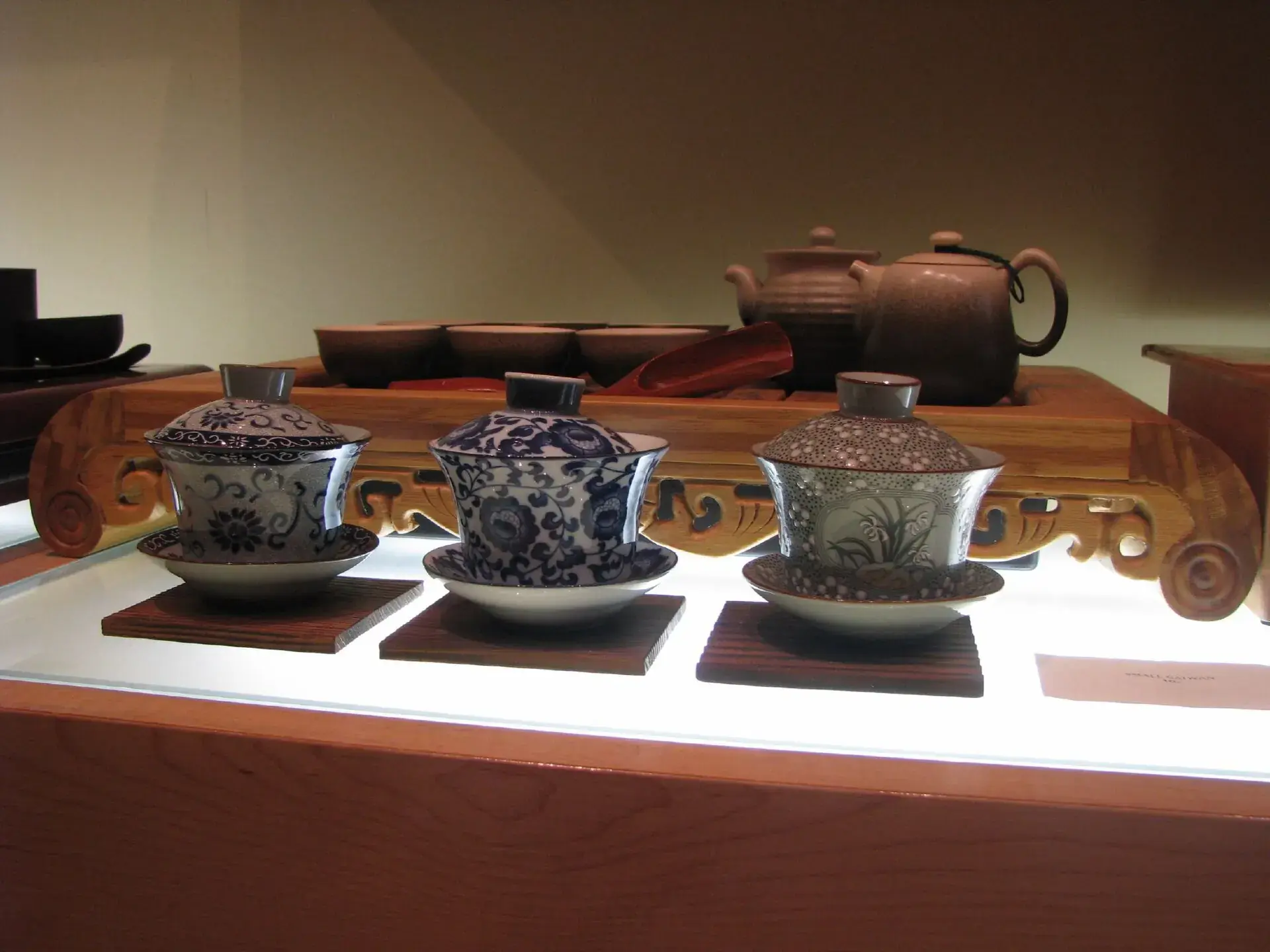 Lidded gaiwan cups set out on a wooden tea table