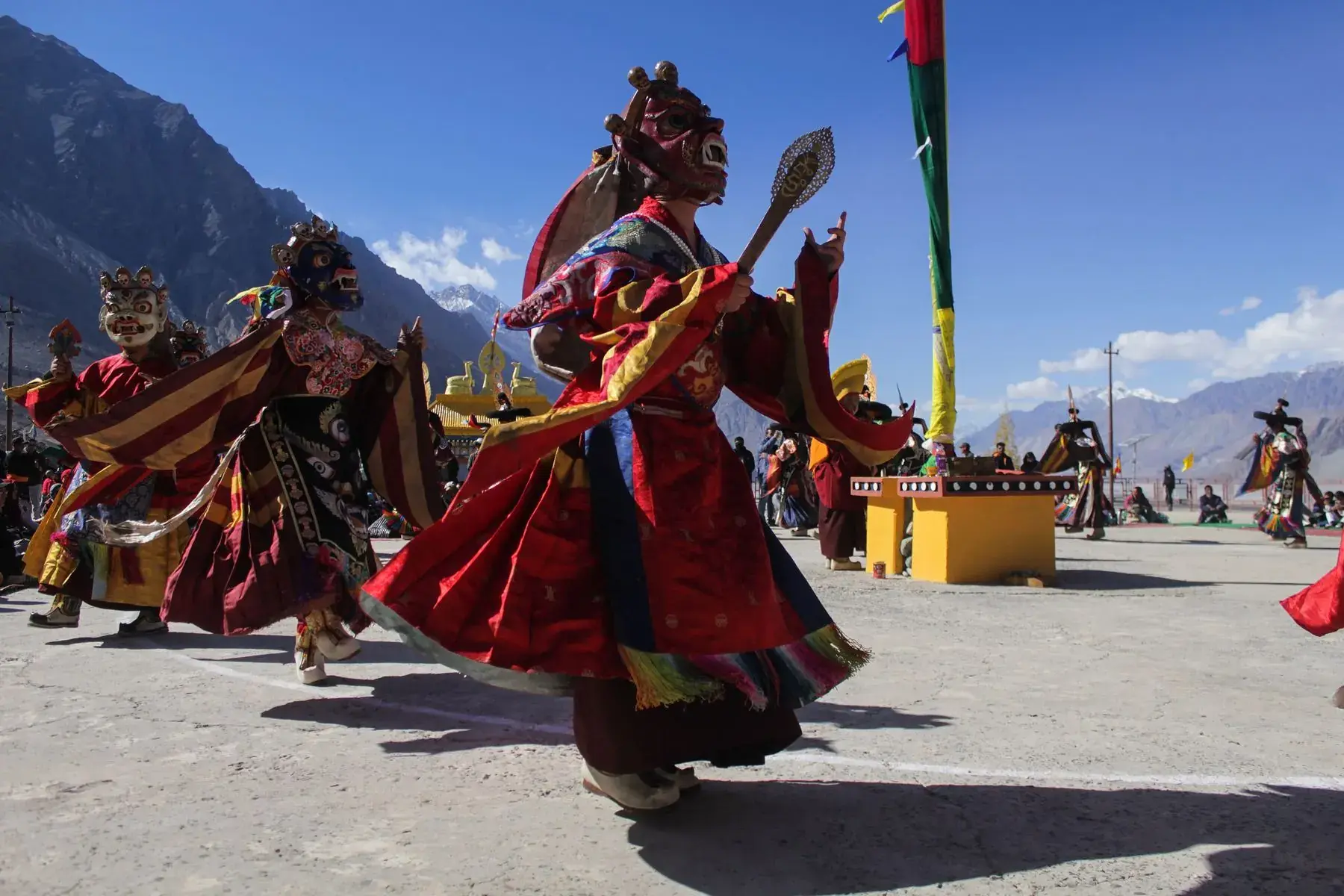 Masked dancers performing in a mountain village square