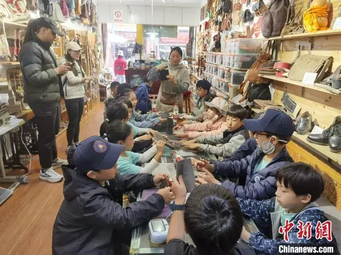 A narrow shop in Songpan old town hung with leather boots, bags and belts