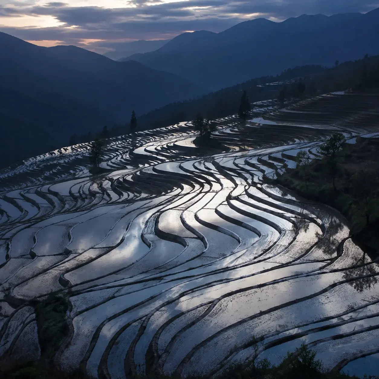 Water-filled Longji terraces mirroring the sky before planting