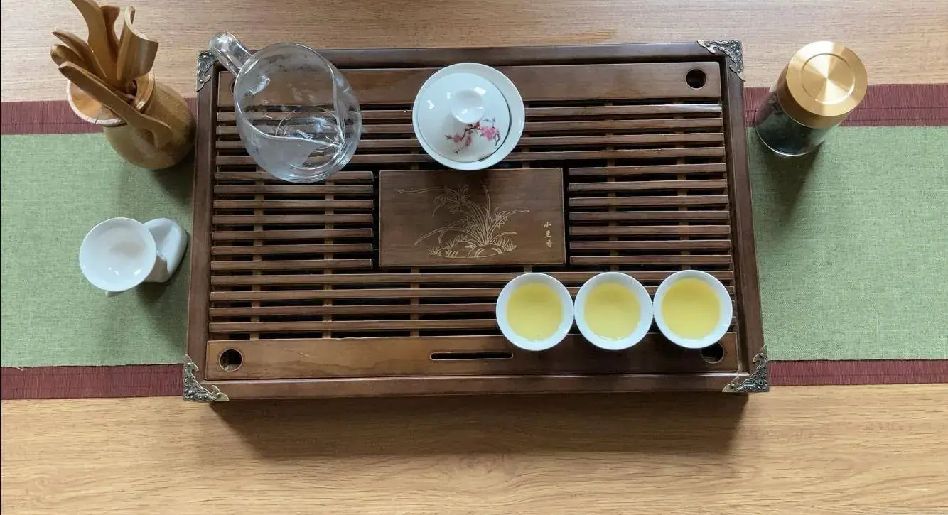 A wooden tea tray with cups, seen from above