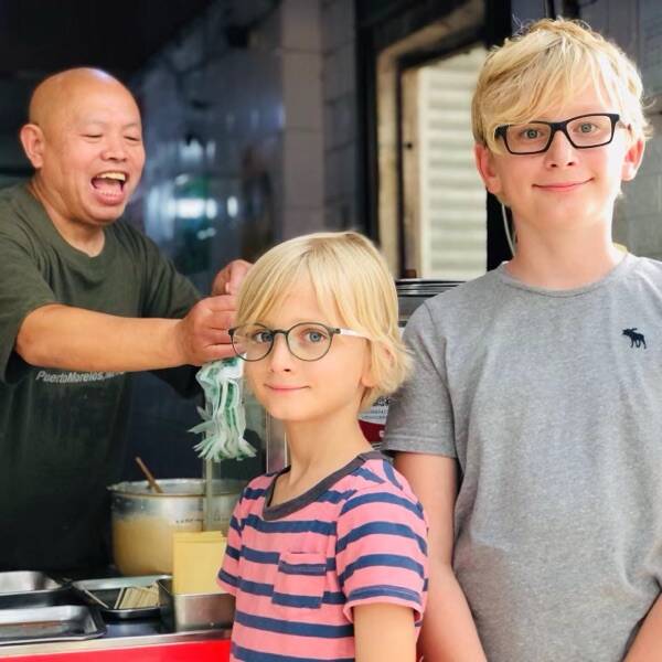 The boys with a laughing shop owner at his counter
