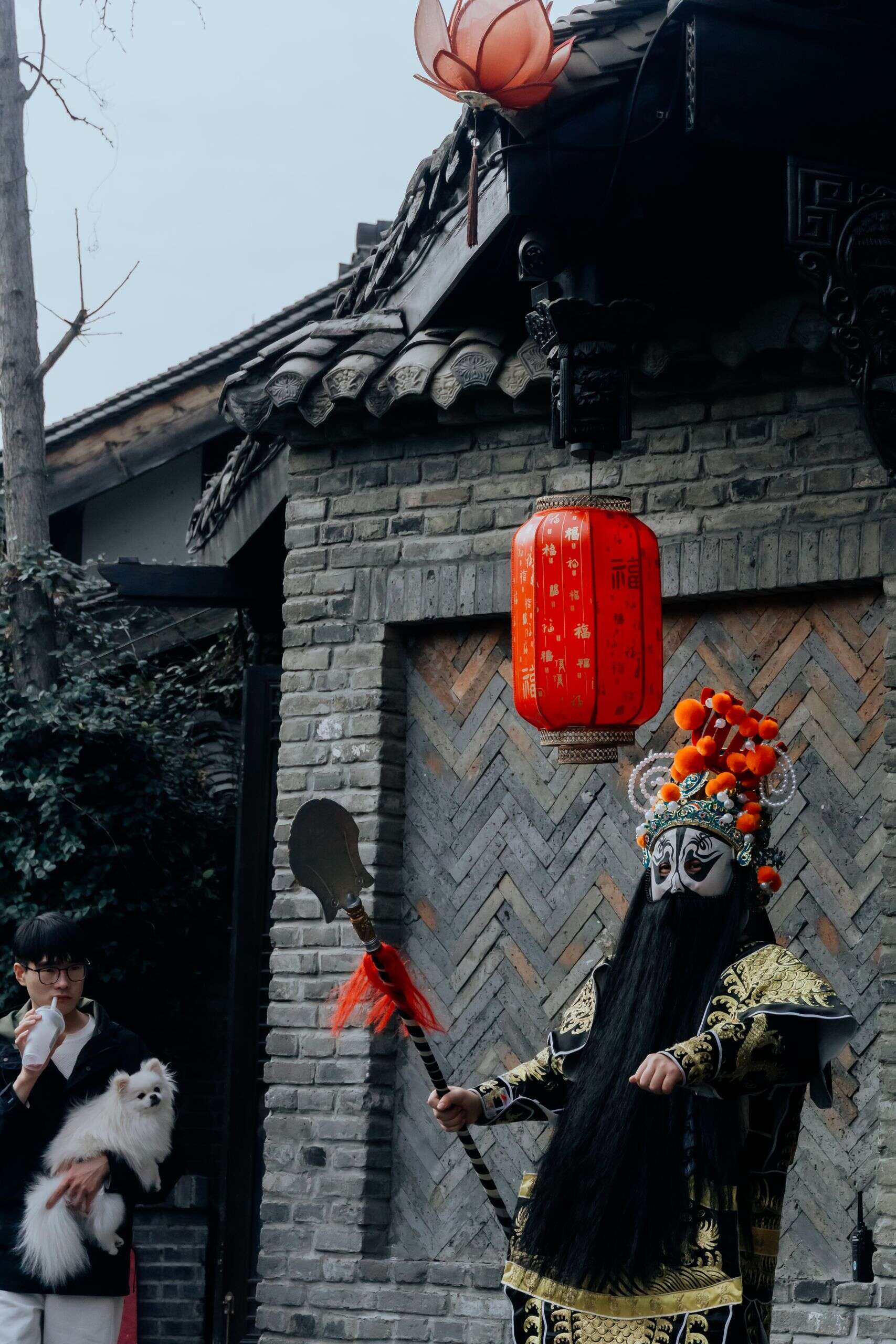 Two Sichuan opera performers on stage in full costume, one in orange, one in red, water sleeves in hand