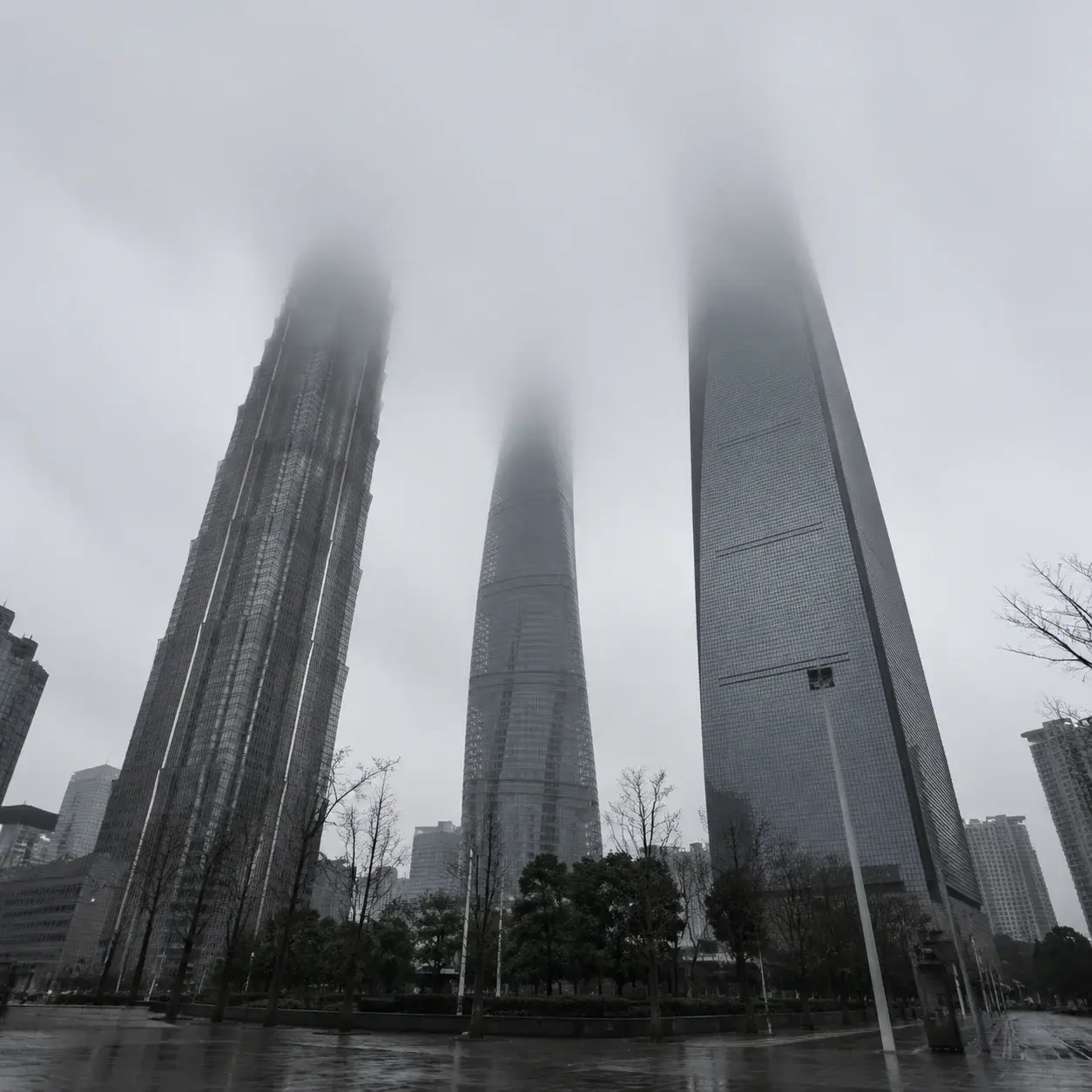 從街頭仰望,上海陸家嘴高樓頂端隱沒在低垂的灰雲中