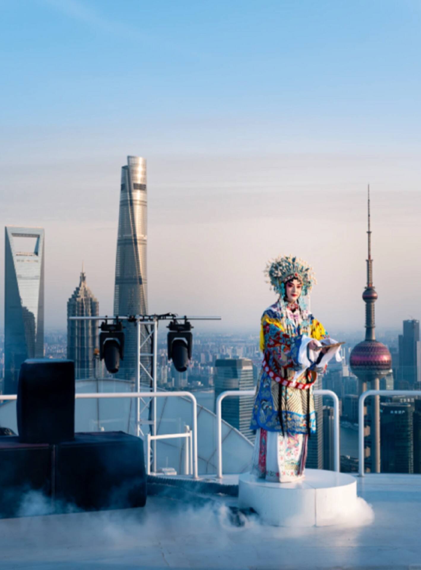 An opera performer on the open stage, Shanghai Tower and the Oriental Pearl behind
