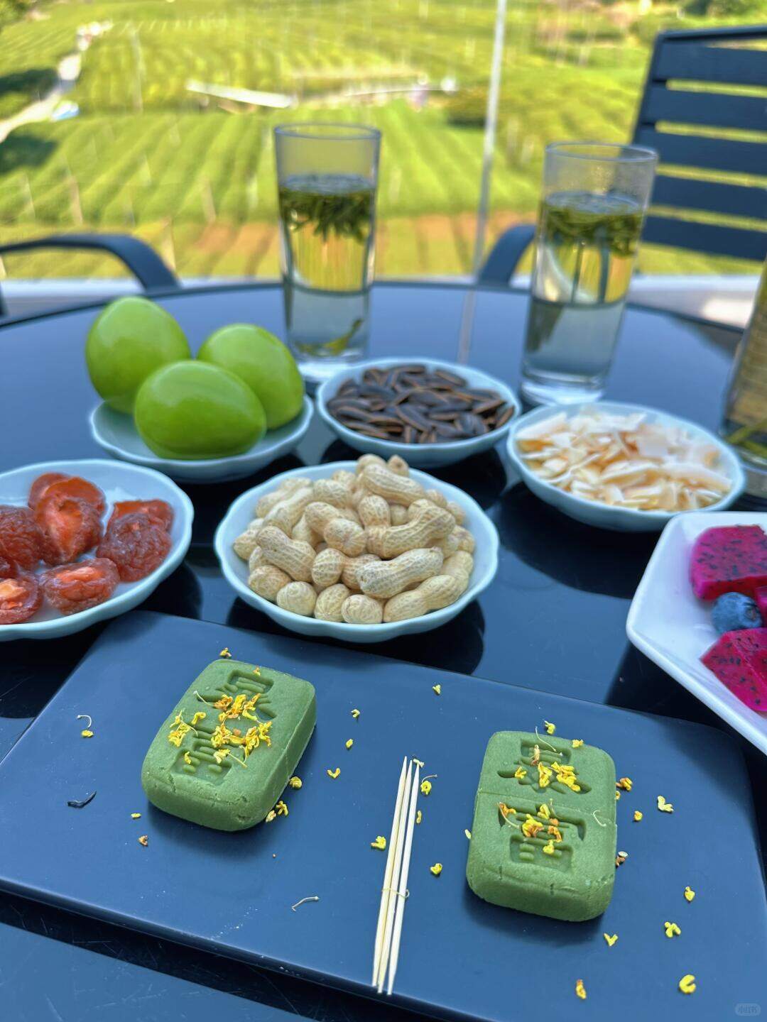A tea table set on the hillside, a cup of Longjing with a few tea snacks