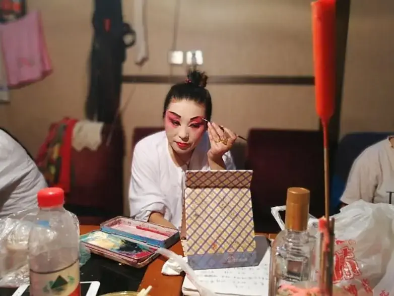 A performer with painted face backstage