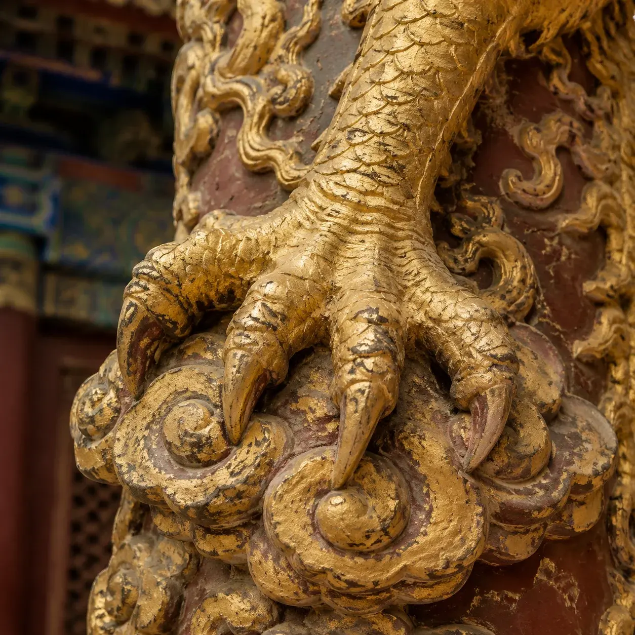 Close-up of a gilded imperial dragon's five-clawed foot on a palace carving