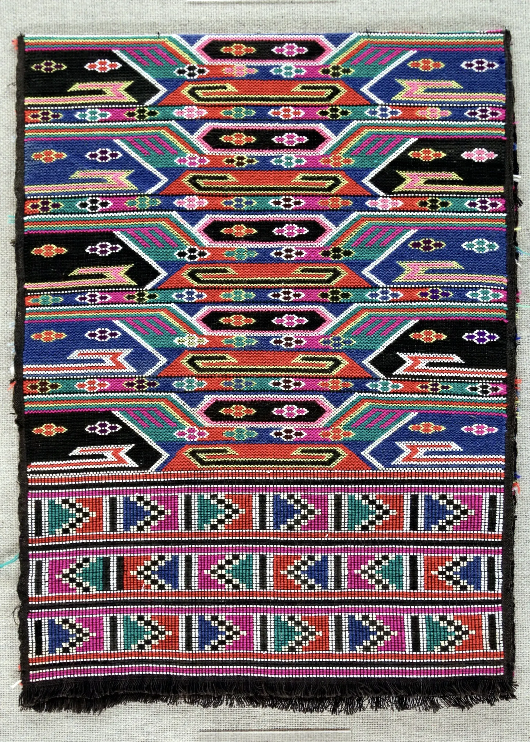 A finished xilankapu panel — the face, woven while looking at the back