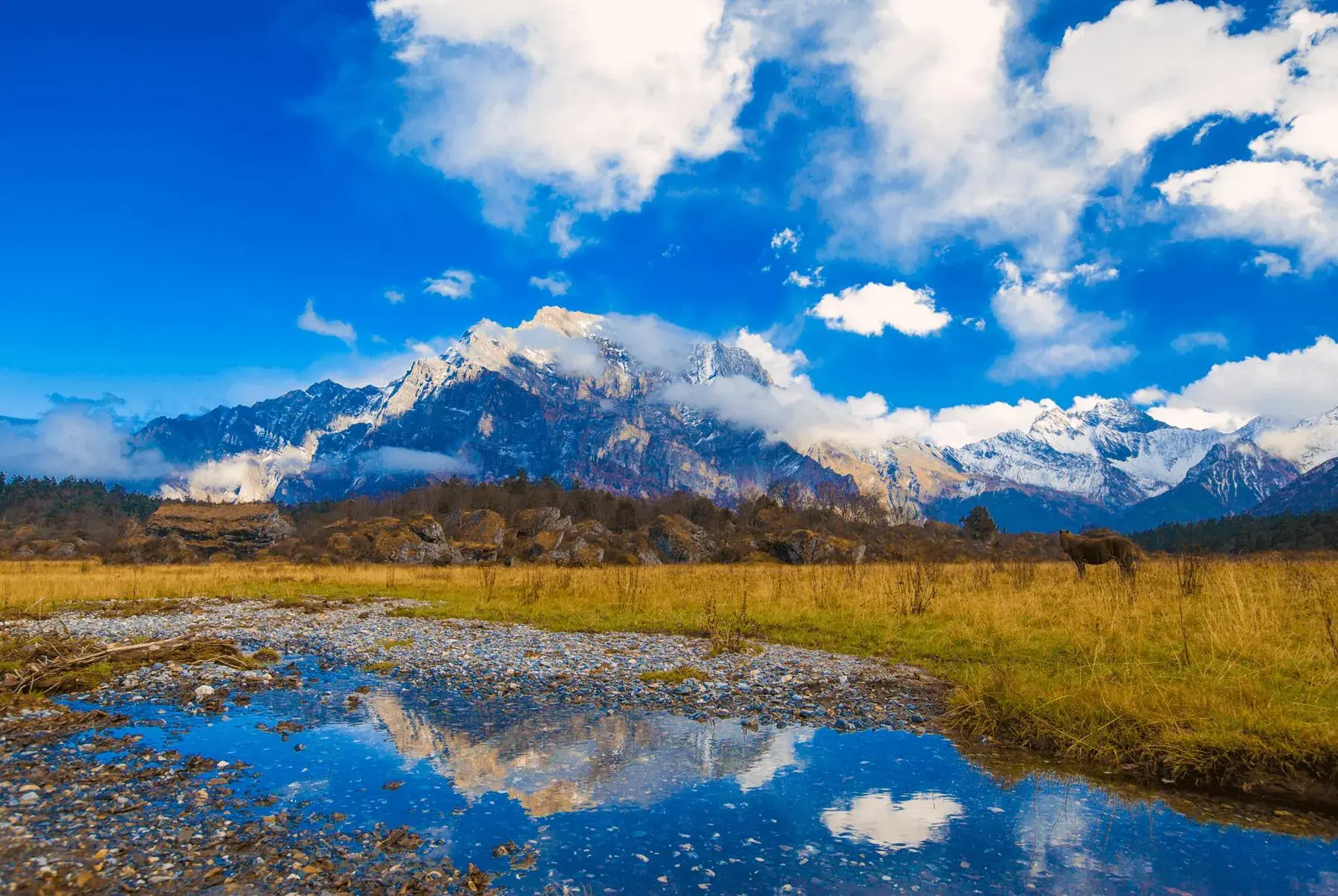 A high-altitude lake below snow mountains