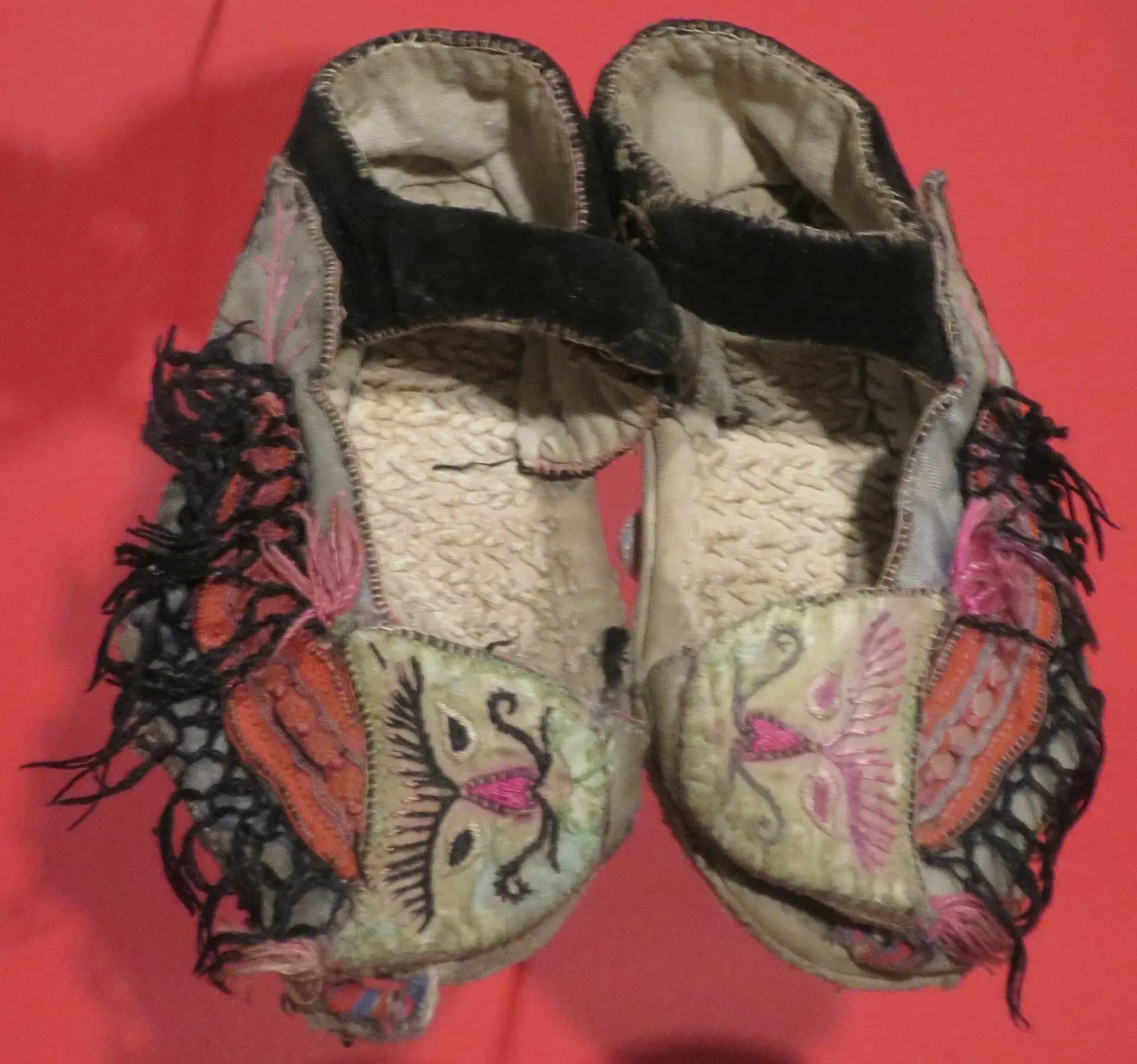 A pair of antique embroidered Chinese cloth shoes, soles worn through