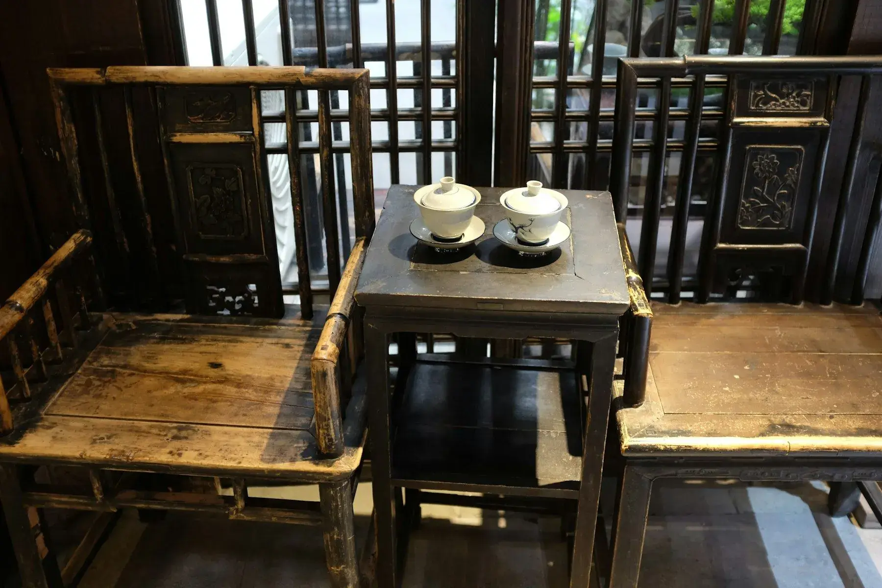 A plain neighbourhood teahouse with wooden chairs and a small stage