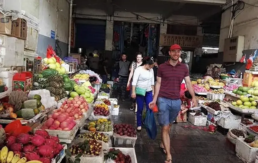 An aisle of fruit and vegetable stalls in a local market