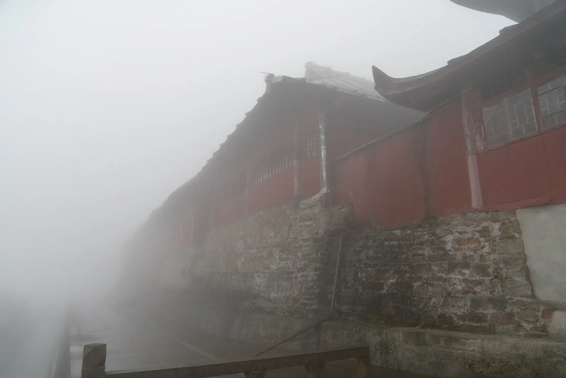 A red monastery wall on Mt Emei, half lost in mist