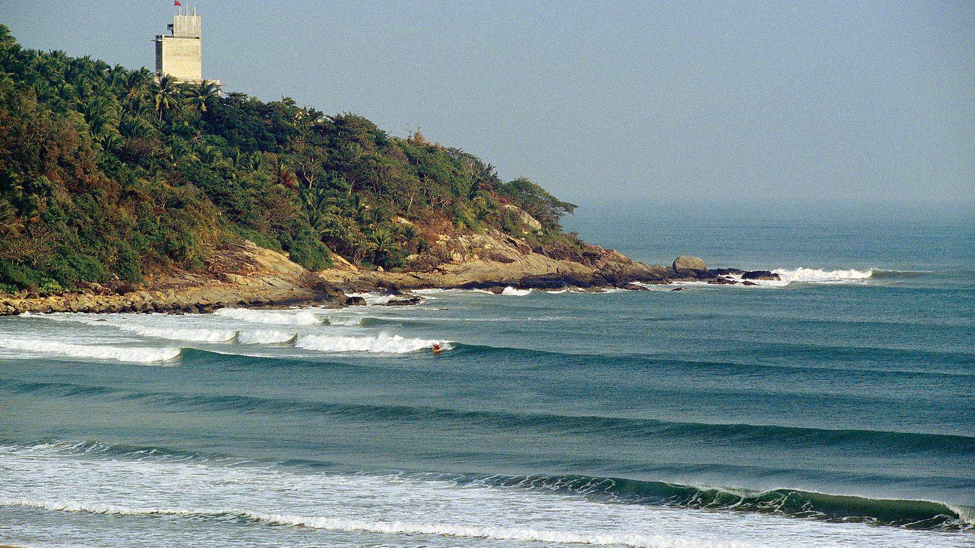 A surfer riding a small wave off Hainan's east coast near Wanning