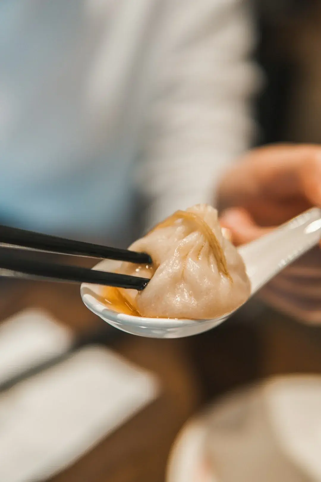 A child eating dumplings with chopsticks at a table