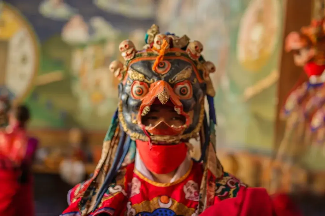 A Sichuan opera performer in a brightly coloured face-changing mask